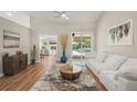 Stylish living room offering hardwood floors, a modern sofa, and an inviting view of the pool area at 5141 Sunnydale W Cir, Sarasota, FL 34233