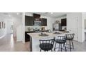 Spacious kitchen featuring dark cabinets, stainless steel appliances, and an island with bar seating at 5230 Salt Marsh Rd, Wimauma, FL 33598