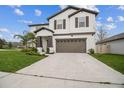 Charming two-story home with well-manicured lawn and a two-car garage, offering curb appeal and convenience at 6241 Spider Lily Way, New Port Richey, FL 34653