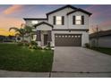 Charming two-story home with well-manicured lawn and a two-car garage, offering curb appeal and convenience at 6241 Spider Lily Way, New Port Richey, FL 34653