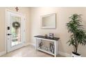 Welcoming foyer with a decorative mirror, table with decor, tile floor, and a lovely plant at 6345 Vista Verde E Dr, Gulfport, FL 33707
