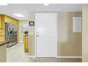 Hallway view with a white front door, stainless steel refrigerator and kitchen at 7300 Sun Island S Dr # 802, South Pasadena, FL 33707