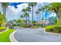 Gated community entrance featuring brick pillars, iron gates, and lush landscaping with manicured green lawns at 8907 Ashford Gables, Tampa, FL 33626