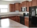 Well-equipped kitchen with black appliances and granite countertops with island at 10111 Rosemary Leaf Ln, Riverview, FL 33578