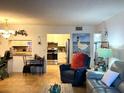 Comfortable living room view into kitchen featuring stainless steel appliances and white cabinetry at 1109 Pine Ridge W Cir # F1, Tarpon Springs, FL 34688