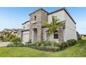 Attractive elevation of a two-story home with stone accents, landscaping, and a well-manicured lawn at 13176 Twin Bridges Dr, Riverview, FL 33579