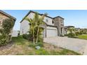 Side angle of a two-story home with stone, neutral siding, landscaping, and paved driveway at 13176 Twin Bridges Dr, Riverview, FL 33579