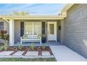 Charming front porch with a bench, decorative pillows, and stylish landscaping at 1842 Oklahoma Ne Ave, St Petersburg, FL 33703