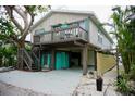 Two-story home with elevated sundeck, surrounded by mature trees and tropical plants at 2504 Avenue B # A, Bradenton Beach, FL 34217