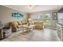 Bright and airy living room with neutral walls, wood-look flooring, and plenty of natural light at 29312 Marker Loop, San Antonio, FL 33576
