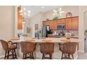 Stylish kitchen with granite countertops, mosaic backsplash, and breakfast bar seating at 313 Old Windsor Way, Spring Hill, FL 34609