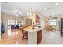 Bright, open floor plan with a kitchen island, dining area, and living room with wood floors at 313 Old Windsor Way, Spring Hill, FL 34609