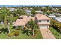 Aerial view of waterfront home with lush landscaping and a brick driveway at 520 74Th St, Holmes Beach, FL 34217