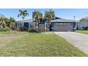 Charming home featuring a modern garage door, lush landscaping, and well-manicured lawn at 5451 Oakhurst Dr, Seminole, FL 33772