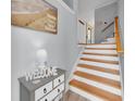 Welcoming entryway featuring a staircase and a charming welcome table and beach-themed decor at 7100 Islamorada Cir, Seminole, FL 33777
