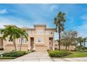 Inviting townhouse with beige exterior, palm trees and well-maintained landscaping at 7100 Islamorada Cir, Seminole, FL 33777