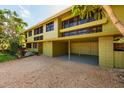 Two-story home with large windows, a gravel driveway, a covered carport, and lush greenery at 724 69Th S Ave, St Petersburg, FL 33705