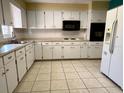 Functional kitchen featuring white cabinets and tiled floors at 7406 Coventry Dr, Port Richey, FL 34668