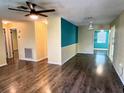 Spacious living room featuring wood flooring, ceiling fans and fresh paint at 7406 Coventry Dr, Port Richey, FL 34668