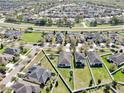 Suburban homes and green spaces, seen from above, display organized neighborhood layout and backyard privacy at 8220 Round Leaf Ln, Riverview, FL 33578