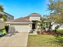 Charming single-Gathering home featuring a two-car garage and well-manicured front lawn, perfect for suburban living at 8220 Round Leaf Ln, Riverview, FL 33578