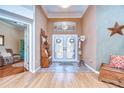 Elegant foyer with a decorative glass transom, double doors, tile flooring, and stylish furnishings at 10130 Paddock Oaks Dr, Riverview, FL 33569