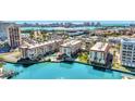Aerial view showcases the condo community, pool, waterfront access, and the beautiful city skyline in the background at 113 Island Way # 241, Clearwater Beach, FL 33767