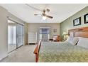 Bright main bedroom features a ceiling fan, a large bed, an exterior door and a dresser with ample space at 113 Island Way # 241, Clearwater Beach, FL 33767