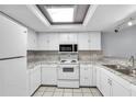 Well-lit kitchen featuring white appliances and tile flooring at 12135 Environmental Dr # 2, New Port Richey, FL 34654