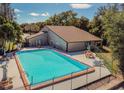 Sparkling community pool surrounded by a fence and sun loungers, perfect for relaxation and recreation at 12135 Environmental Dr # 2, New Port Richey, FL 34654