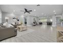 Spacious living room featuring tile floors, a ceiling fan, recessed lighting, and contemporary furnishings and decor at 1466 Laconia W Dr, Clearwater, FL 33764
