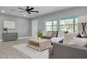 Bright living room with tile floors, comfortable seating, large windows, and a ceiling fan, creating a cozy atmosphere at 1466 Laconia W Dr, Clearwater, FL 33764