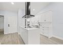 Bright kitchen featuring an island cooktop, stainless steel appliances, and white cabinetry at 1763 Castle Rock Rd, Tampa, FL 33612