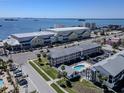 Scenic aerial view featuring a complex with a pool near the calm bay waters on a clear day at 340 Causeway Blvd # 108, Dunedin, FL 34698