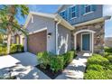 Charming home with a stone accent wall, blue front door, lush landscaping, and two-car garage at 4522 Tramanto Ln, Wesley Chapel, FL 33543