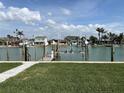 Lush backyard space with access to a canal, featuring a boat lift, and picturesque water views at 525 Crystal Dr, Madeira Beach, FL 33708