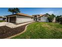 A well-manicured lawn with sidewalks leading to the front door and a two car garage at 5342 Sagamore Ct, New Port Richey, FL 34655
