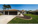 Well manicured lawn with sidewalks leading to the front door and two car garage at 5342 Sagamore Ct, New Port Richey, FL 34655