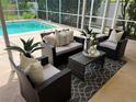Relaxing screened-in patio with stylish wicker furniture, perfect for enjoying the outdoors by the pool at 5342 Sagamore Ct, New Port Richey, FL 34655
