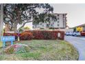 An exterior view of the condo building shows lush landscaping and assigned parking for residents at 6269 Palma Del Mar S Blvd # 111, St Petersburg, FL 33715