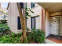 Exterior of unit 111 with lush landscaping, a secure front door, and designated parking at 6269 Palma Del Mar S Blvd # 111, St Petersburg, FL 33715