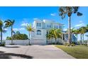 Charming two-story coastal home featuring lush landscaping, an attached two-car garage, and a spacious driveway at 829 Blue Heron Blvd, Ruskin, FL 33570