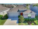 Aerial view of a well-maintained home, showcasing the roof, driveway, landscaping, and proximity to neighboring houses at 10115 Paradise Fish Dr, Riverview, FL 33578