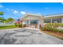 Inviting front porch of a home featuring a blue front door, ornate metal chairs, and lovely landscaping at 11601 86Th Ave, Seminole, FL 33772