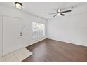 Bright living room featuring wood-look floors, a ceiling fan, and natural light streaming through the window at 1256 Redondo Way, Wesley Chapel, FL 33543
