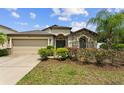 Charming single Gathering home featuring a stone facade, mature landscaping and a two car garage at 1426 Main St, Valrico, FL 33594