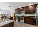 Well-appointed kitchen featuring stainless steel appliances, dark wood cabinetry and a breakfast bar at 1426 Main St, Valrico, FL 33594