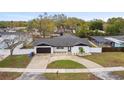 Aerial view of a lovely home with a dark roof, two-car garage, fenced yard, and inviting pool at 1621 S Keene Rd, Clearwater, FL 33756