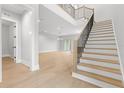 Bright foyer featuring wood-look tile floors, a staircase, and a neutral color palette at 216 N Hesperides St, Tampa, FL 33609