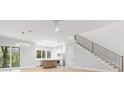 Open-concept living space featuring wood-look tile floors and staircase at 216 N Hesperides St, Tampa, FL 33609